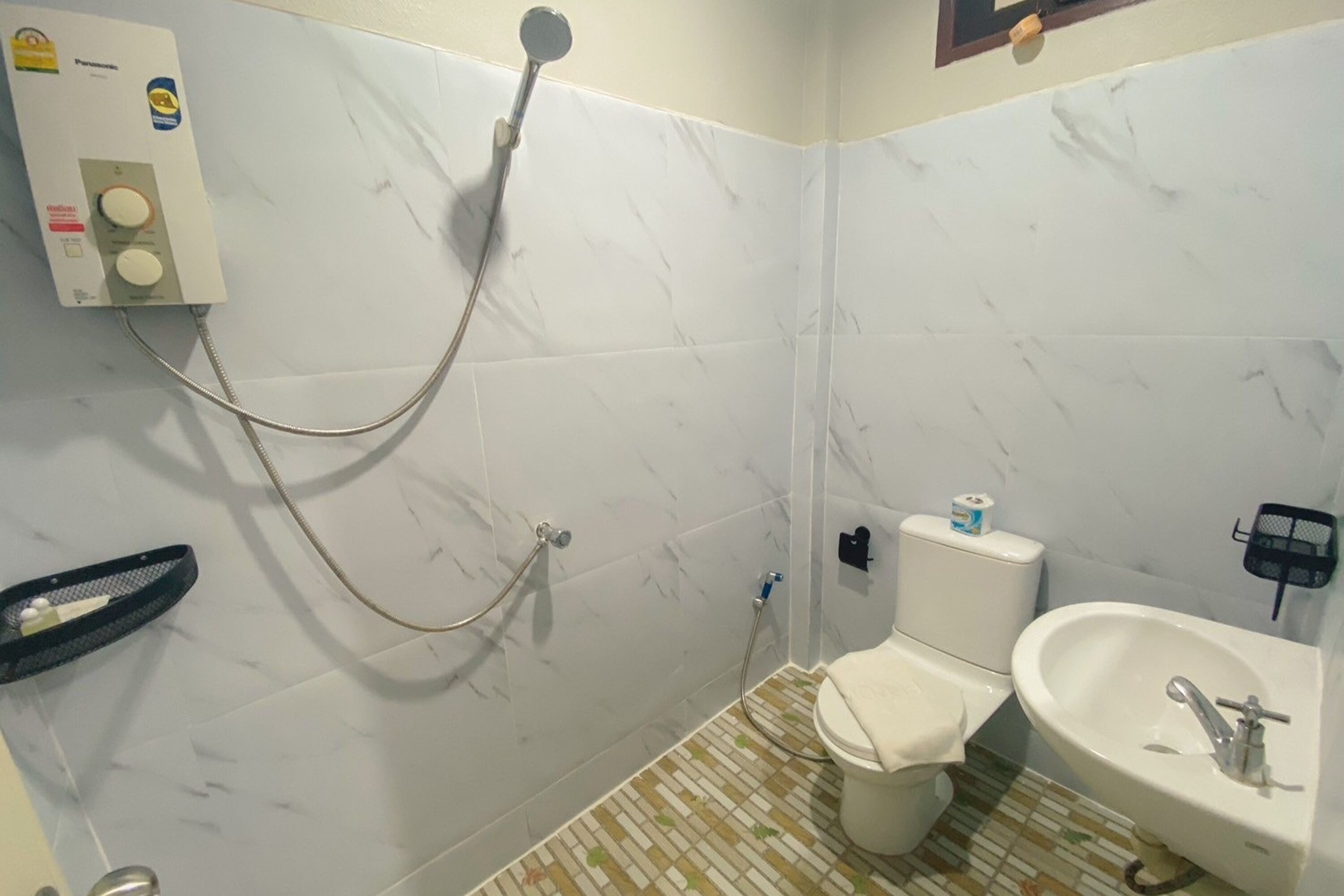 A bathroom with a toilet, sink, and shower.