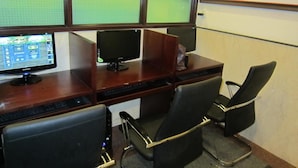 Un escriptori amb dos monitors, un teclat i dues cadires de treball.