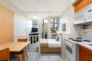 Cocina compacta con estufa, microondas y comedor.