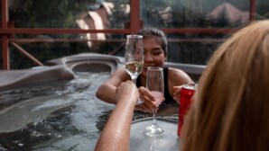 A hot tub with two people toasting with wine glasses. - Alpenglow Lodge by MountainView (Whistler)