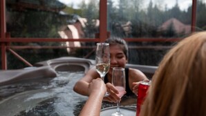 A hot tub with two people holding glasses. - Alpenglow Lodge by MountainView (Whistler)