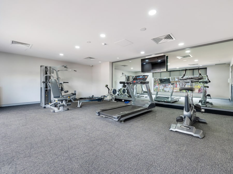 A gym with treadmills, elliptical machines, and weight equipment.