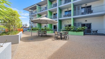 A multi-story hotel with outdoor seating and greenery.