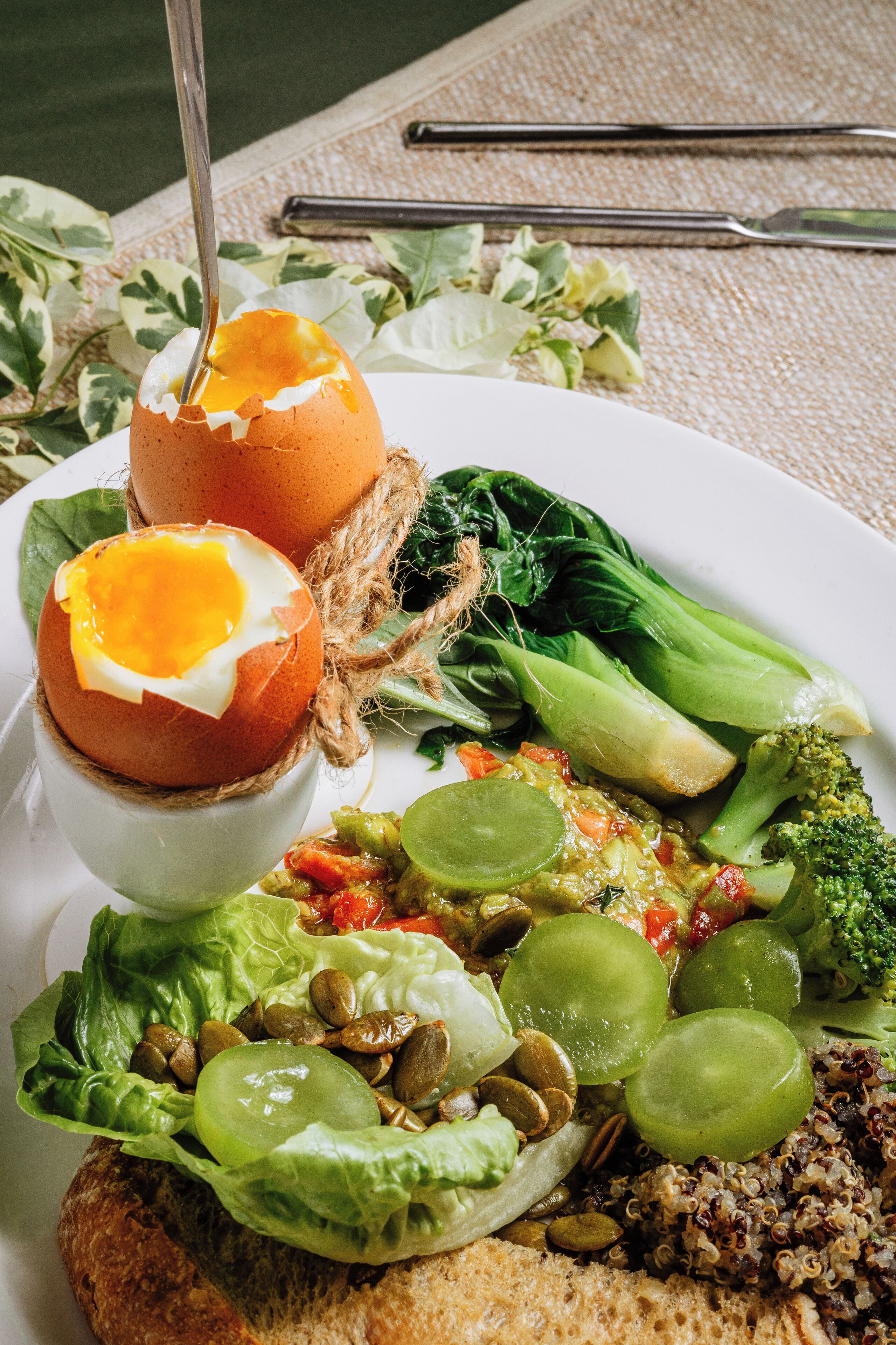 A plate with a variety of foods including eggs, vegetables, and grains.