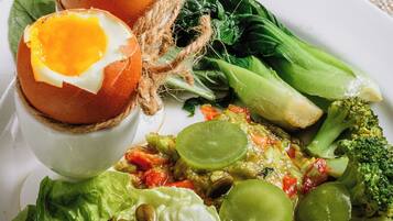 A plate with a variety of foods including eggs, vegetables, and grains.