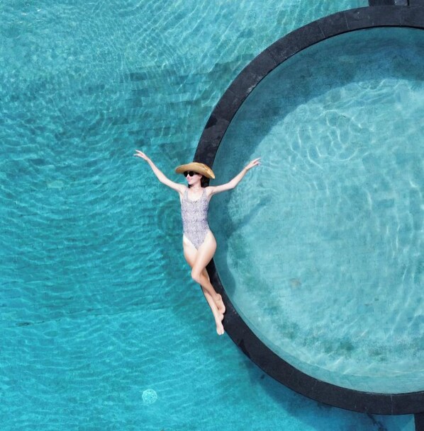 Una piscina al aire libre, sillones reclinables de piscina