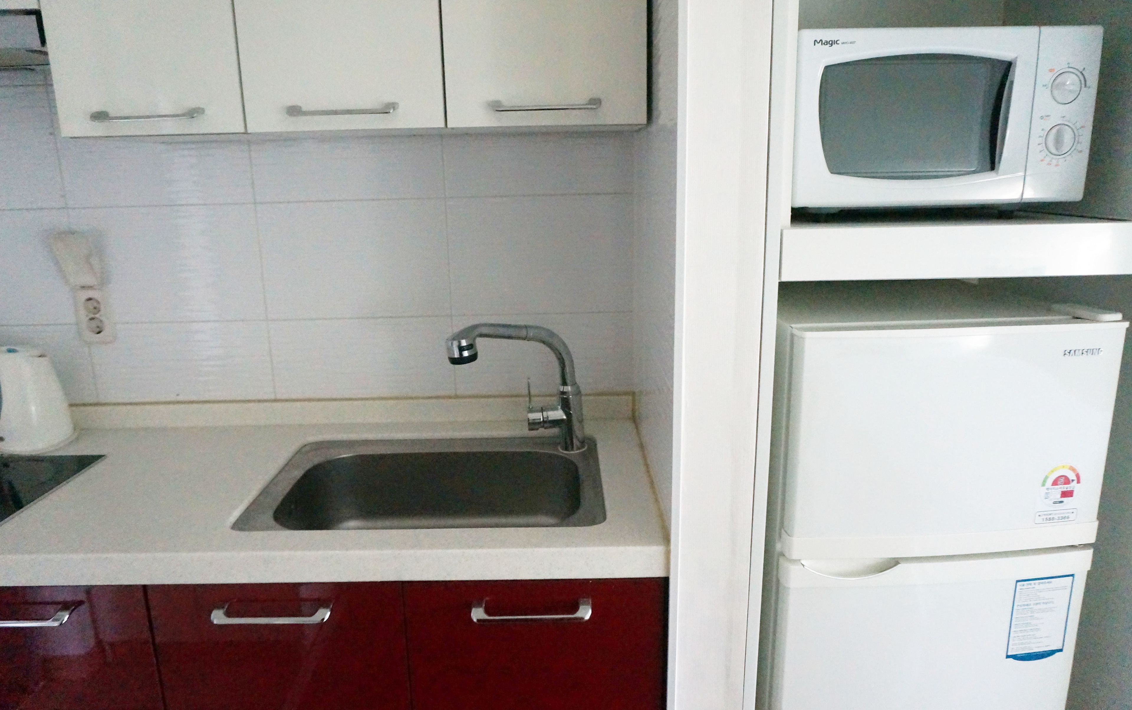 A kitchen with a sink, a microwave, and a refrigerator.