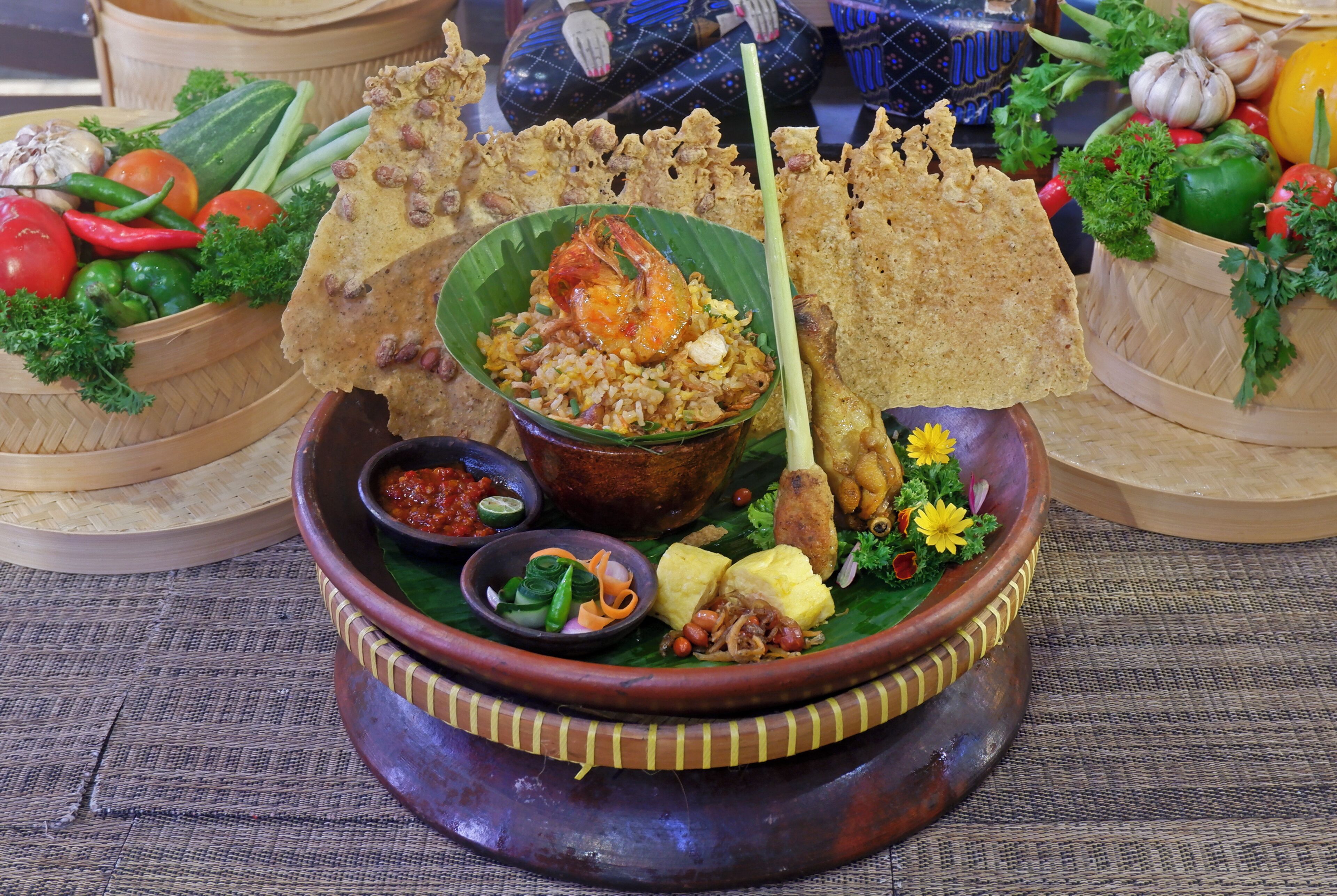 A traditional meal with rice, vegetables, and a shrimp dish, served on a banana leaf.