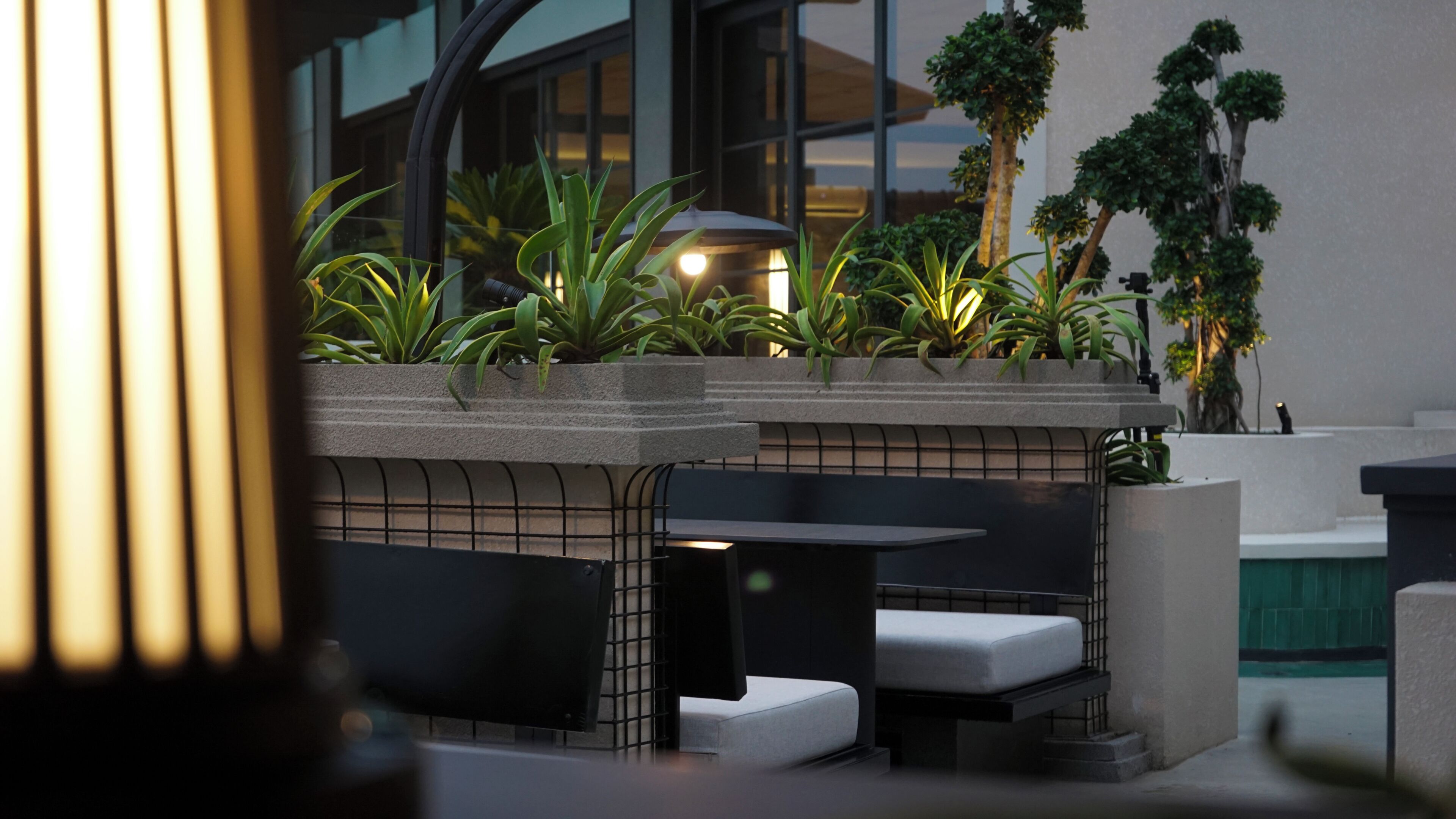 An outdoor seating area with planters, a bench, and a table.