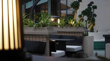 An outdoor seating area with planters, a bench, and a table.