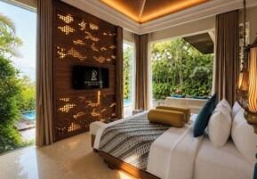 Habitación de hotel moderna con una cama grande, televisión y vistas a una piscina y zonas verdes.
