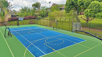 Una cancha de baloncesto al aire libre con aro, tablero y línea de tiro libre.