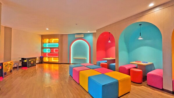 A brightly lit room with colorful seating, a reception desk, and a large arched doorway.