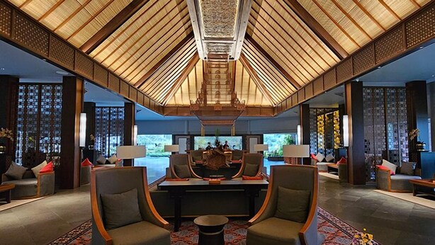 A spacious lobby with a high ceiling, a central seating area, and a view of the outdoors. - The Singhasari Resort (Batu)