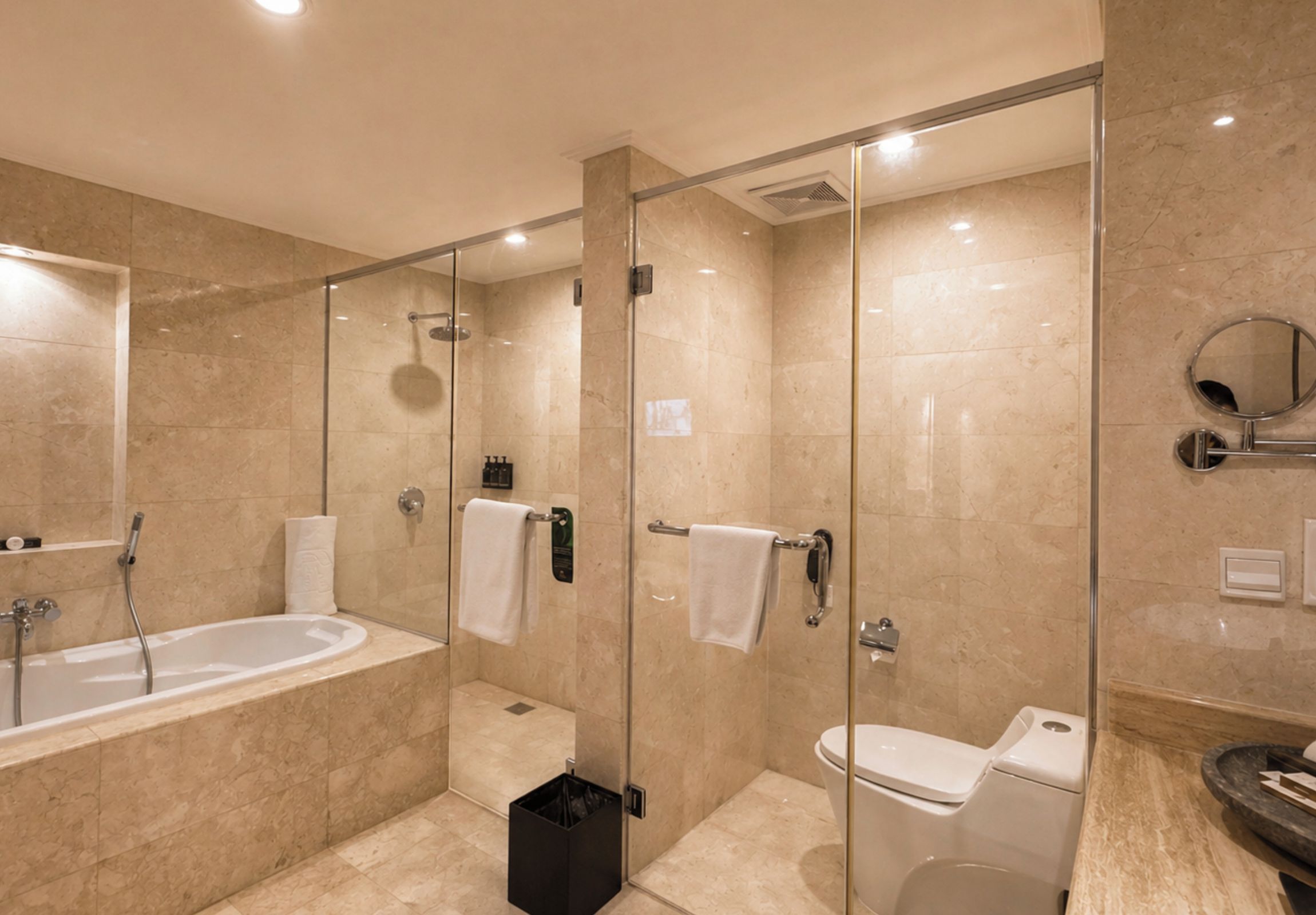 A modern bathroom with a glass-enclosed shower, a standalone bathtub, and a toilet.