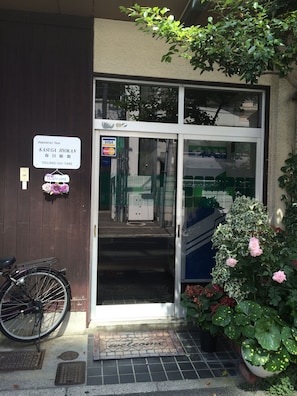 Ein Hotel Eingang mit einem Schild, das anzeigt, dass es sich um das Japanese Inn, Kasuga Ryokan handelt.