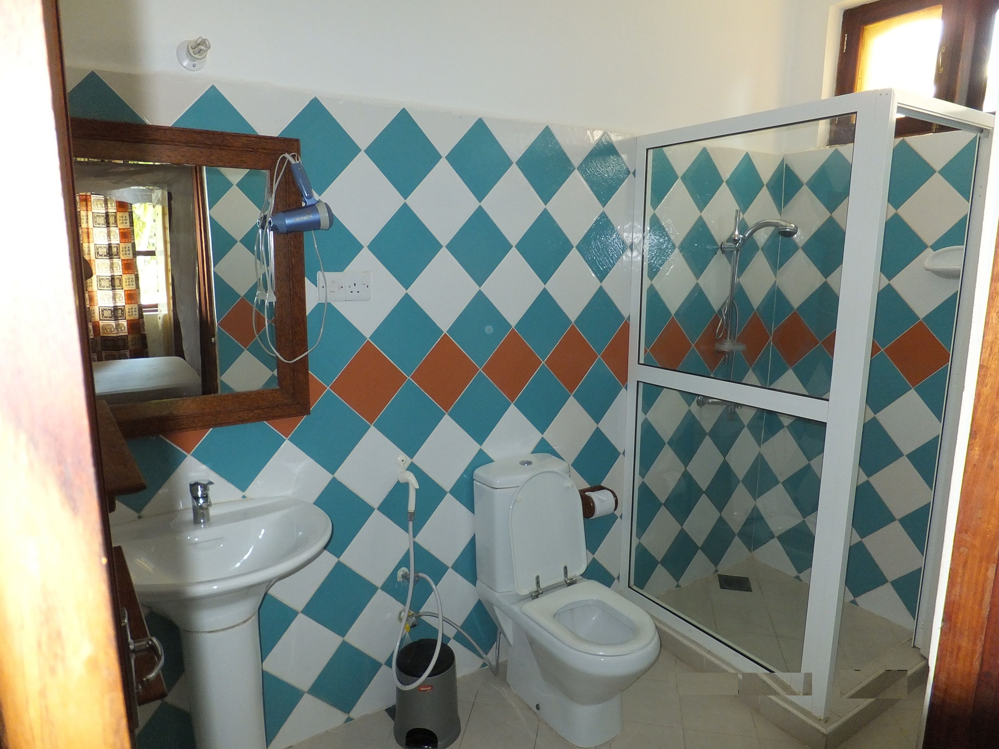 A bathroom with a sink, toilet, and glass-enclosed shower.