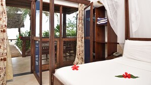 Une chambre d’hôtel avec un lit, un bureau en bois, un téléphone et une vue sur l’extérieur.