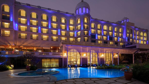 A large hotel with multiple floors, a swimming pool, and a covered outdoor area. - Radisson Blu Plaza Hotel Mysore (Mysore)