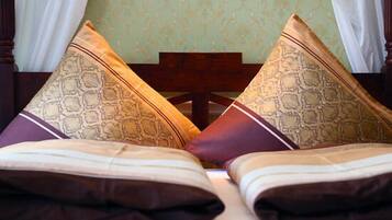 A bed with patterned pillows and a wooden headboard.