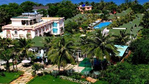 A resort with multiple buildings, a swimming pool, and palm trees. - Aris Resort (Phu Quoc)
