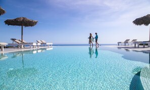 Piscine extérieure en saison, piscine à débordement, parasols