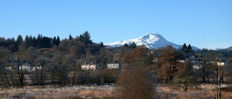 A snow-capped mountain with houses in the foreground.