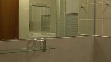 Un baño con lavamanos, inodoro y espejo.