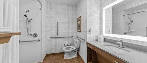 A modern bathroom with a shower, toilet, and vanity.
