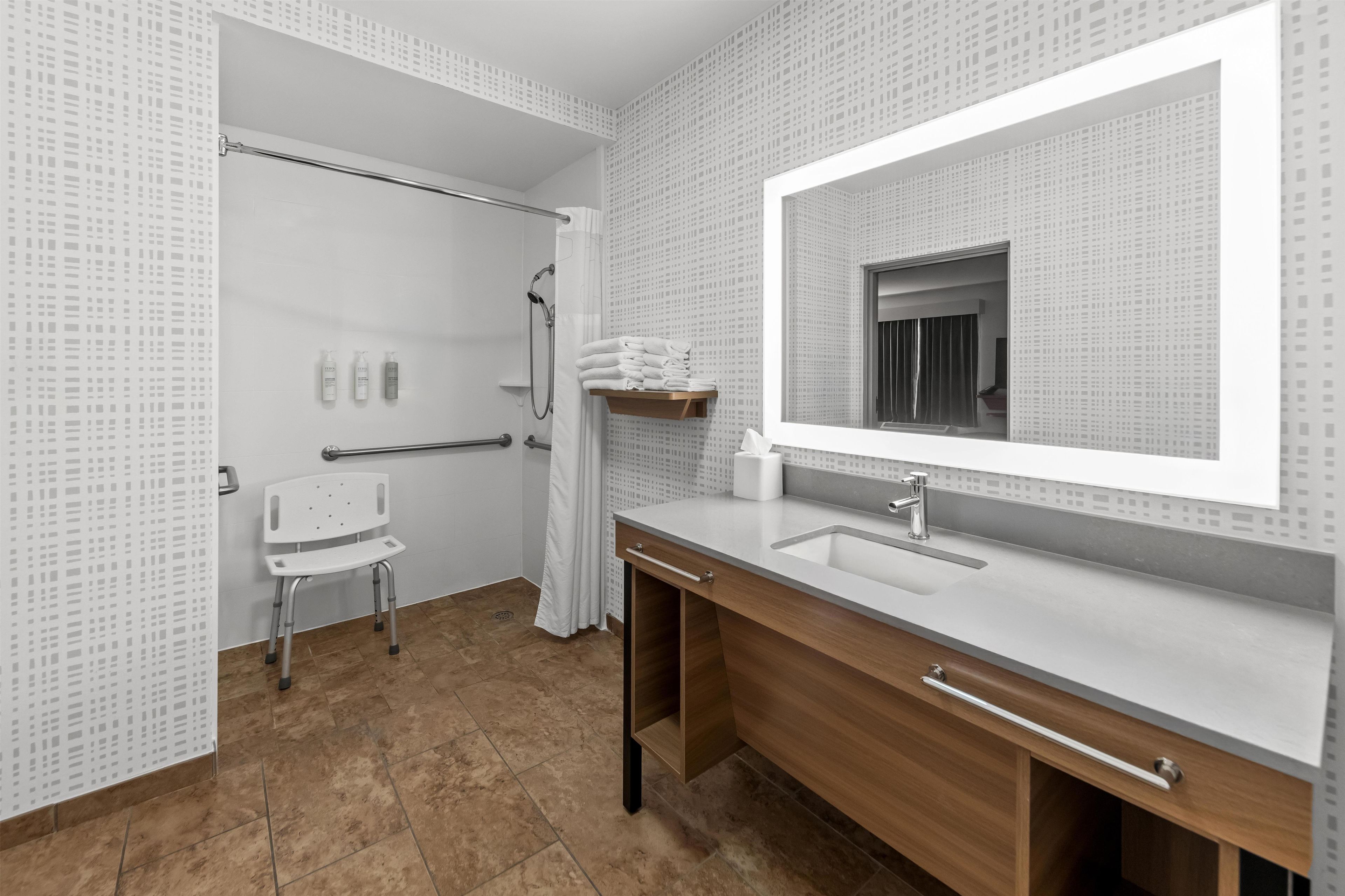 Un baño con ducha, inodoro, lavabo y espejo.