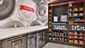 A snack display area with various packaged snacks and a 'TREAT' sign. - Hampton Inn & Suites Dallas Market Center (Dallas)