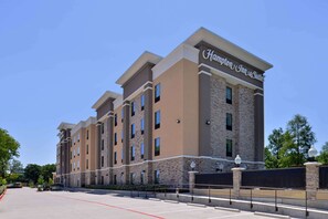 A Hampton Inn Suites building with a stone facade, multiple windows, and a clear sky. - Hampton Inn & Suites Dallas Market Center (Dallas)
