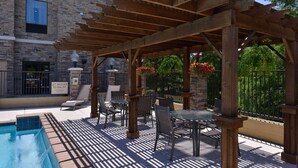 A poolside area with a pergola, outdoor seating, and a lifeguard station. - Hampton Inn & Suites Dallas Market Center (Dallas)