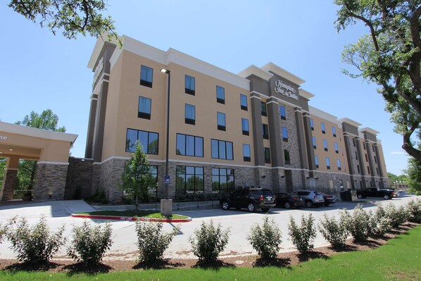 A hotel with a modern design, featuring multiple floors and a prominent entrance. - Hampton Inn & Suites Dallas Market Center (Dallas)