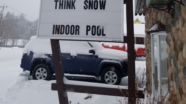 A motel sign with "Clarks Beach Motel on the Lake" and "Think Snow Indoor Pool" text. - Clark's Beach Motel (Old Forge)