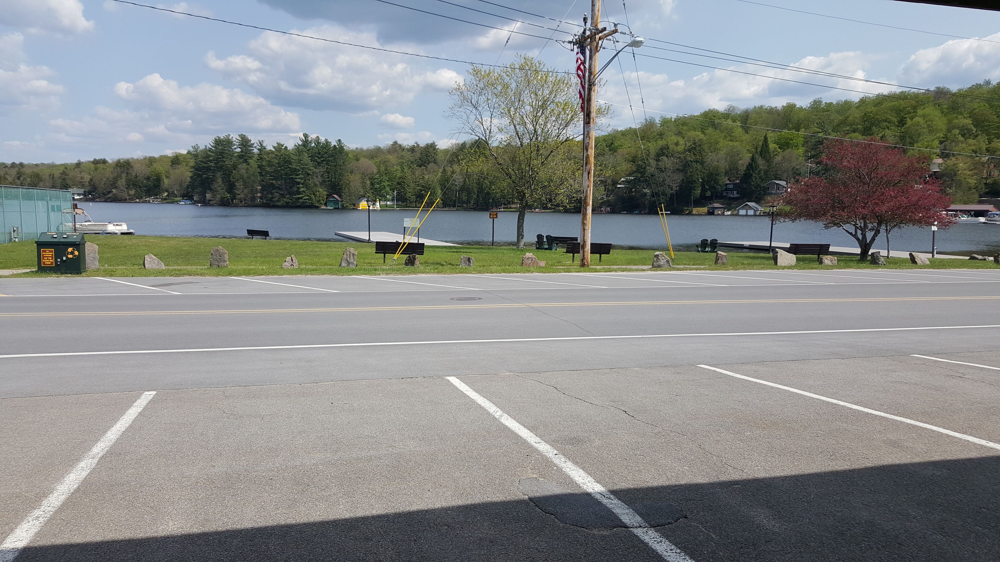 A parking lot with a view of a lake and trees in the background.