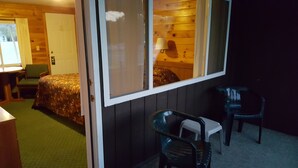 A room with a bed, a chair, a small table, and a window. - Clark's Beach Motel (Old Forge)
