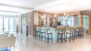 Een moderne keuken met een marmeren eiland, barkrukken en een groot raam.