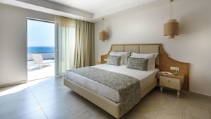 Een hotelkamer met een groot bed, een nachtkastje, een venster met gordijnen en uitzicht op de oceaan.