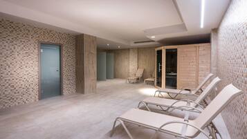 Relax in a serene spa area with lounge chairs, sauna, and seating area.