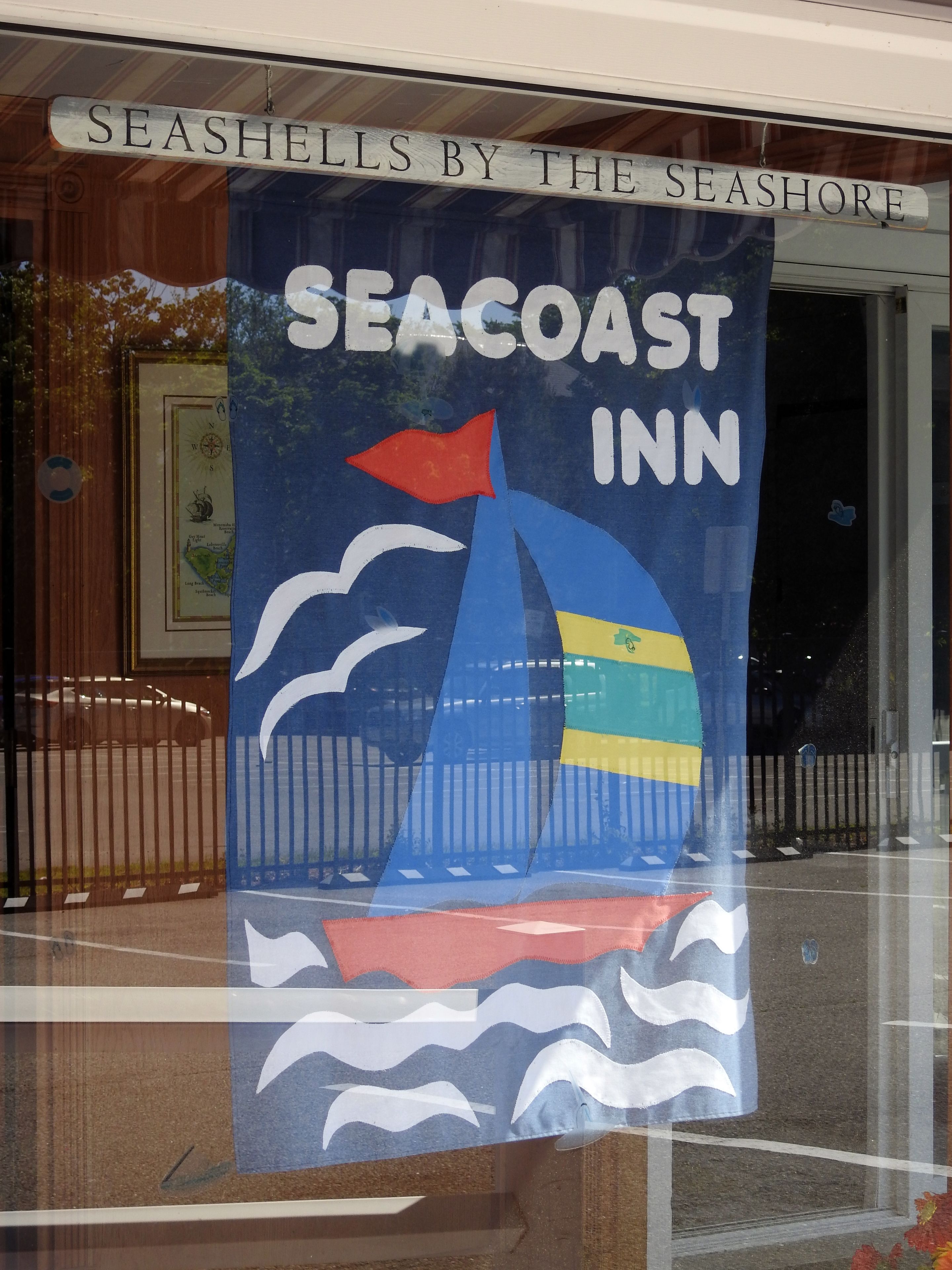 A banner with the text "SEASHELLS BY THE SEASHORE" and "SEACOAST INN" along with a sailboat graphic.