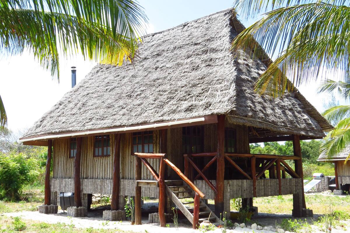 A thatched-roof building with wooden beams and a porch.