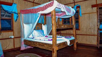 A wooden bunk bed with a canopy, a woven mat on the floor, and a window with a curtain.