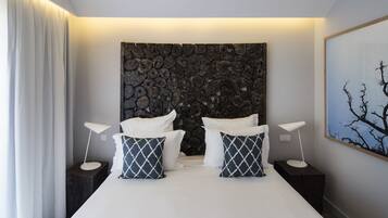 A modern bedroom with a large bed, two nightstands, and a unique wooden headboard.