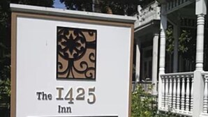 Une enseigne pour l’établissement The 1425 Inn, avec un logo décoratif et l’année de sa création.