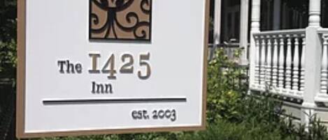 A sign for The 1425 Inn with a decorative logo and establishment year.