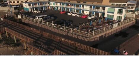 A multi-story motel with a parking lot and a fenced area.