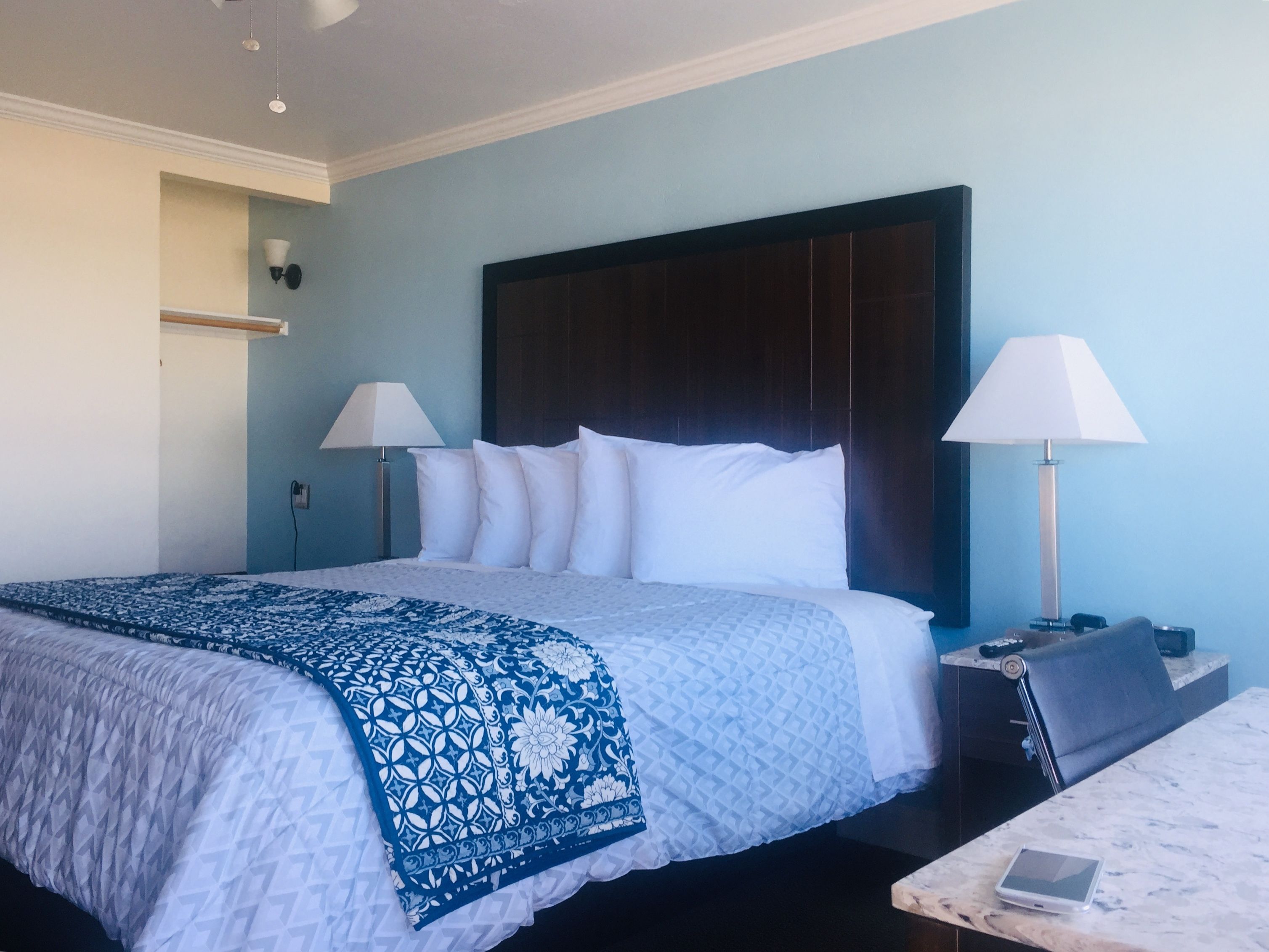 Camera d'albergo con un letto grande, due abat-jour, un comodino e un tavolino.