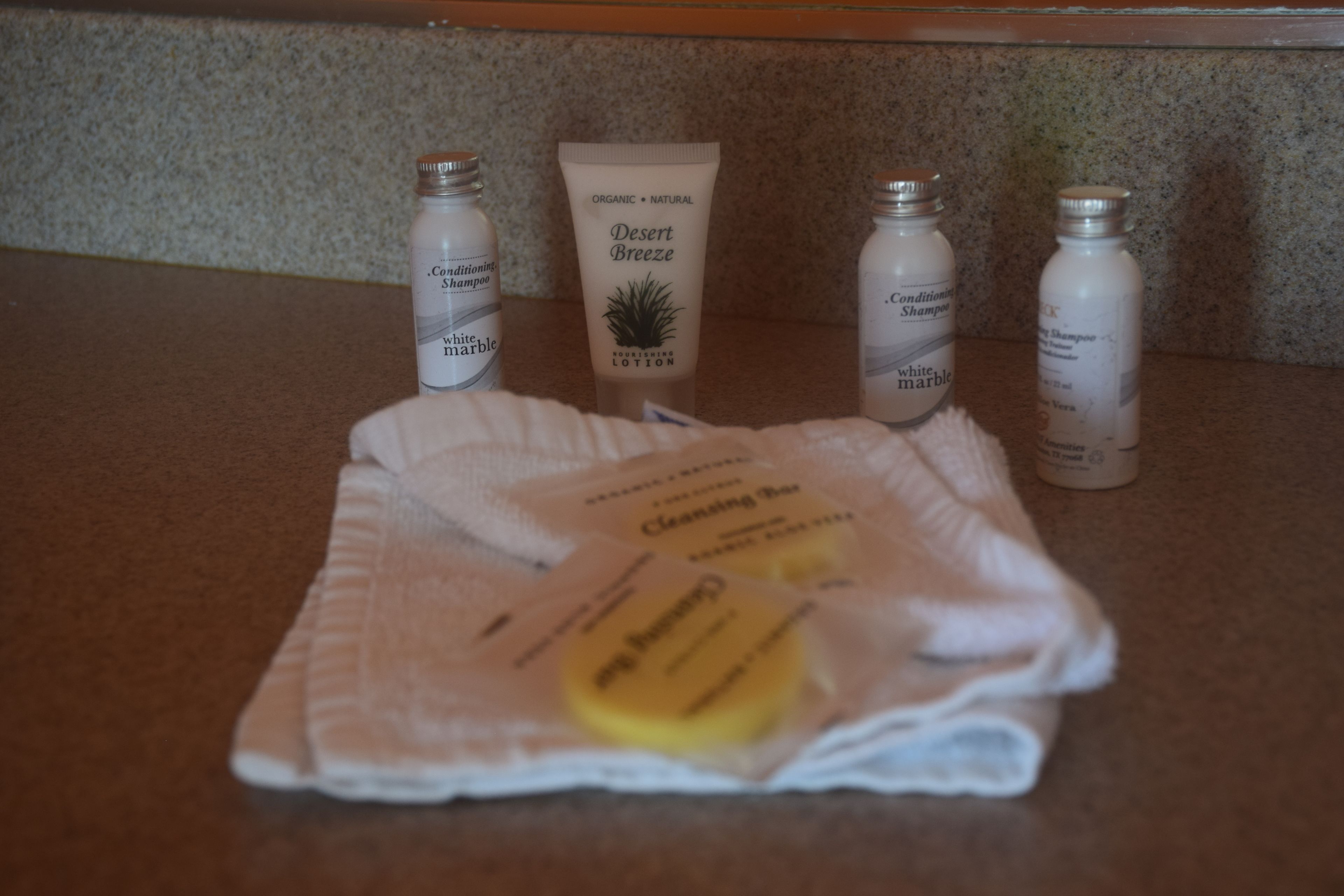 A countertop with four bottles of Desert Breeze products and a package of cleaning wipes.