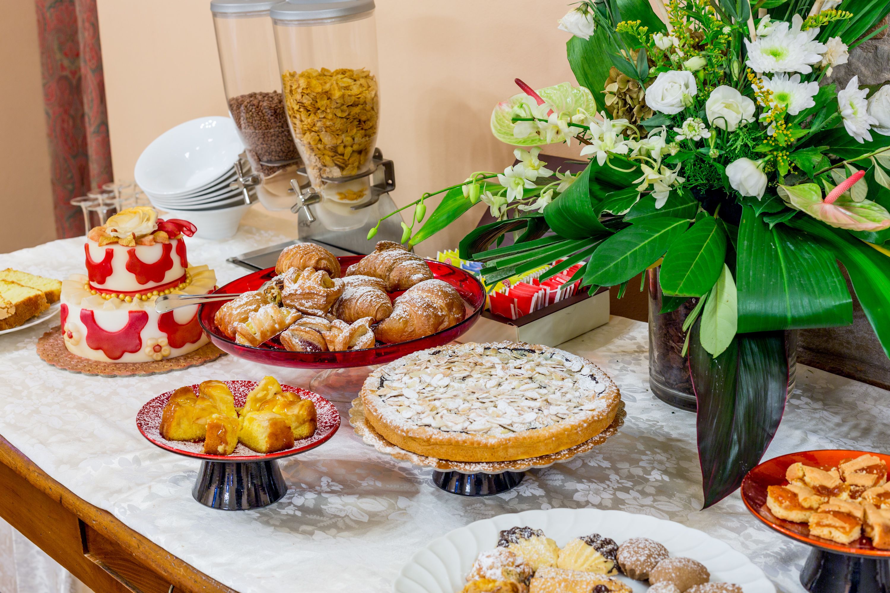 Una mesa de buffet con diversos postres y una decoración floral.